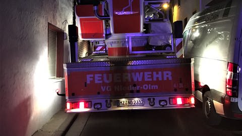 Bei einem nächtlichen Einsatz kommt ein Feuerwehrfahrzeug der Verbandsgemeinde Nieder-Olm kaum durch eine enge Straße. Ein Lieferwagen  (Foto: Freiwillige Feuerwehr der Verbandsgemeinde Nieder-Olm)