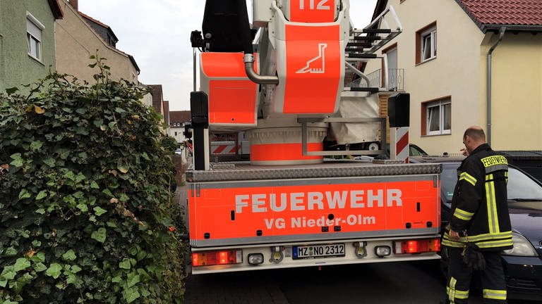 Ein Feuerwehrauto kommt bei einem Einsatz in der Verbandsgemeinde Nieder-Olm nicht weiter, weil es zwischen einer Mauer und einem parkenden Auto zu eng ist.  (Foto: Feuerwehr der Verbandsgemeinde Nieder-Olm)