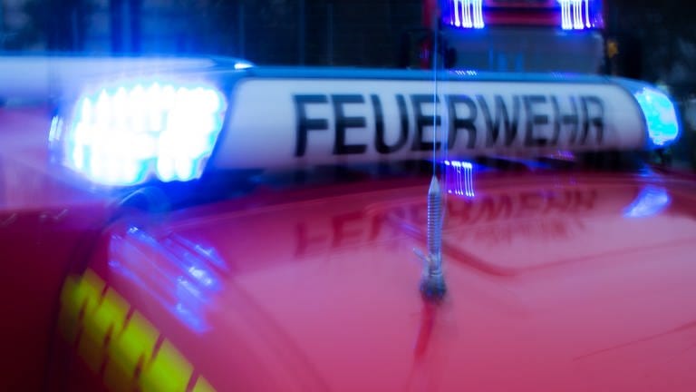 Ein Einsatzfahrzeug der Mainzer Feuerwehr fährt mit Blaulicht zu einem Einsatzort.