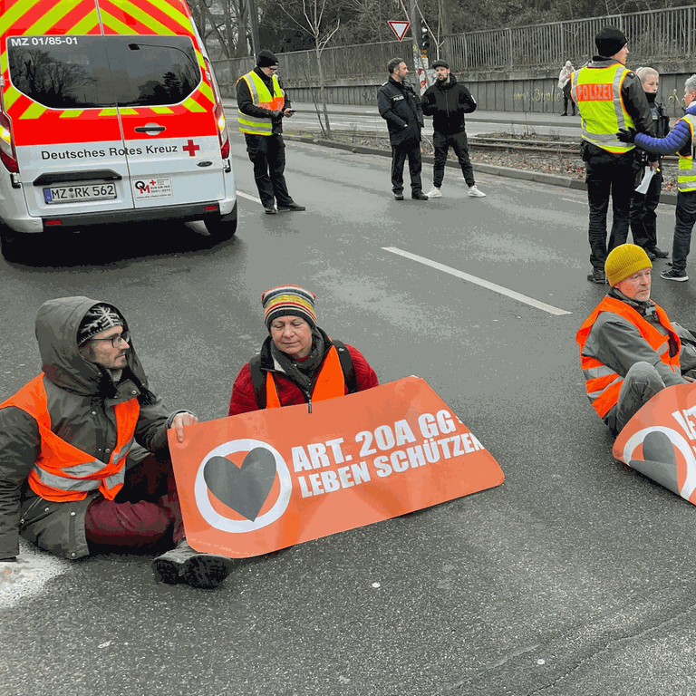 Klimaaktivisten der Letzten Generation haben am Freitagmorgen die Saarstraße in Mainz blockiert. Auf der Straße saßen sechs Menschen. Wegen der kalten Temperaturenhaben hatten sie sich warm angezogen. Einige haben sich an der Straße festgeklebt. Es gab lange Staus.  (Foto: SWR, D. Brusch)
