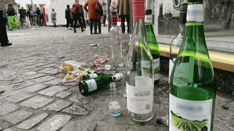 Leere Weinflaschen und Schnapsfläschchen aus Glas liegen in Mainz an Weiberfastnacht auf dem Gehweg. Auf der Partymeile LU und auf dem Schillerplatz herrscht Glasverbot. Nun streikt die Muellabfuhr während der Fastnachtstage. (Foto: SWR, C. Lutz)