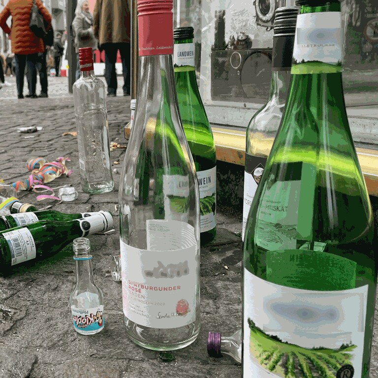 Leere Weinflaschen und Schnapsfläschchen aus Glas liegen in Mainz an Weiberfastnacht auf dem Gehweg. Auf der Partymeile LU und auf dem Schillerplatz herrscht Glasverbot. Nun streikt die Muellabfuhr während der Fastnachtstage. (Foto: SWR, C. Lutz)