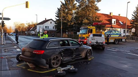 Das kaputte Fluchtauto der Täter und ein kaputtes Polizeiauto werden nach einer Geldautomatensprengung in Mainz-Mombach an Silvester 2021 abgeschleppt
