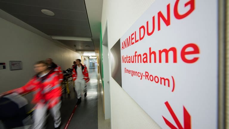 Ein Patient wird durch Sanitäter des Deutschen Roten Kreuzes von der Notaufnahme verlegt.
