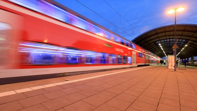 Ein Regionalzug fährt in der Abenddämmerung aus einem Bahnhof.  (Foto: dpa Bildfunk,  Peter Gercke (Symbolbild))