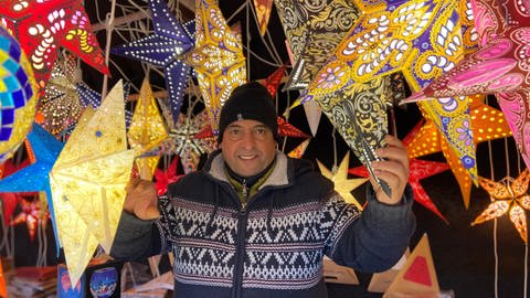 Standbetreiber Ahmed Ballota steht in seinem Stand auf dem Mainzer Weihnachtsmarkt.