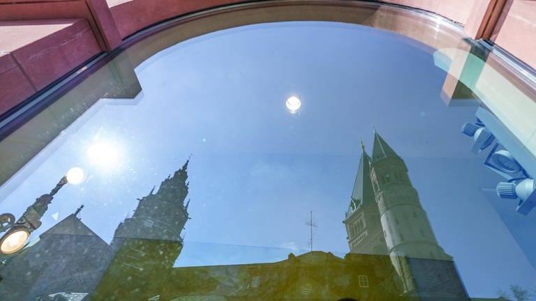 Der Mainzer Dom spiegelt sich in einer Schaufensterscheibe am Marktplatz.