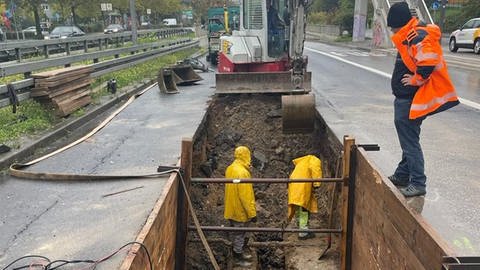 Bauarbeiter versuchen in einer Baugrube, das defekte Wasserrohr zu reparieren. (Foto: ESWE-Versorgung)