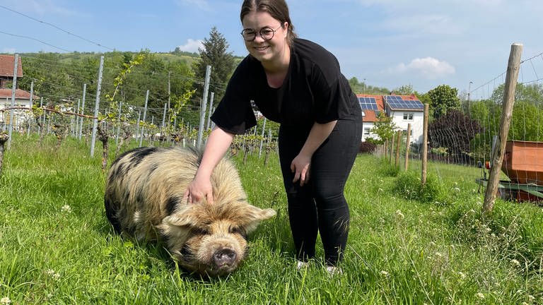 Schwein Emma lässt sich von Winzerin Laurence im Weinberg kraulen. (Foto: SWR, Sibylle Jakobi)