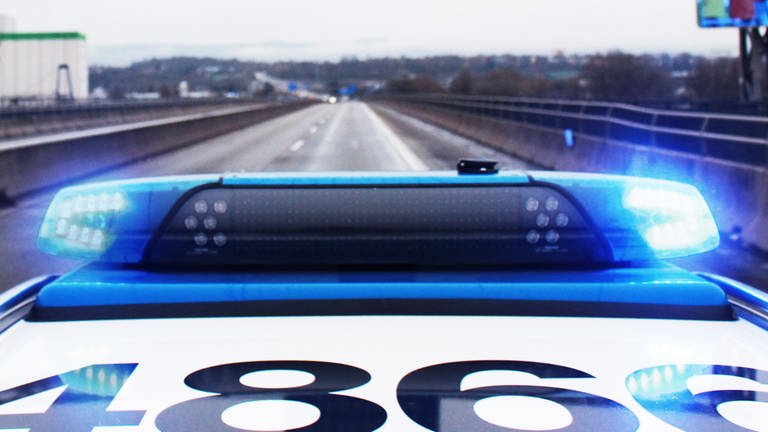 Ein Einsatzfahrzeug der Polizei fährt mit Blaulicht über die Autobahn bei Mainz.