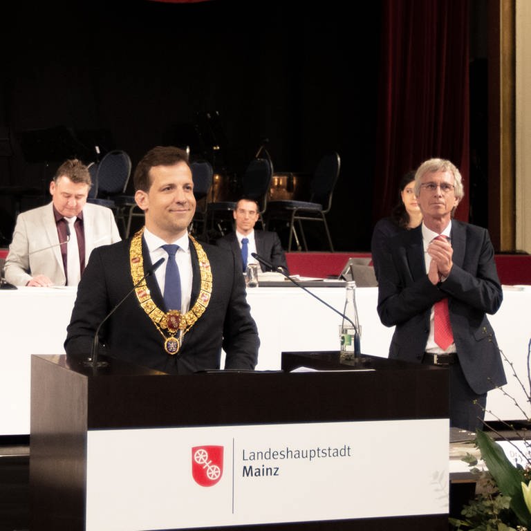 Der neue Mainzer Oberbürgermeister Nino Haase steht mit seiner Amtskette um den Hals vor dem Stadtrat.