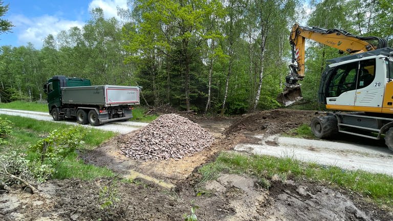 Bagger heben einen Graben im Waldweg aus, der mit groben Steinen aufgefüllt wird (Foto: Landesforsten Rheinland-Pfalz)