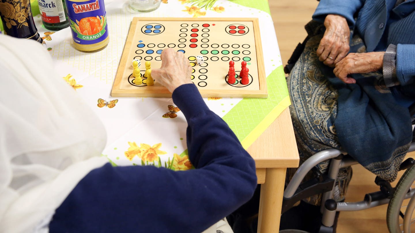 Zwei Seniorinnen aus Afghanistan spielen im Wohnbereich Orient eines Pflegeheims in Hamburg das Gesellschaftsspiel 