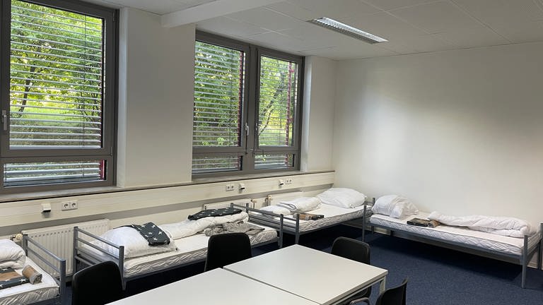 Auf dem Bild sind mehrere Betten in einem Raum zu sehen. Die Stadt Mainz eröffnet eine neue Flüchtlingsunterkunft für etwa 490 Menschen.