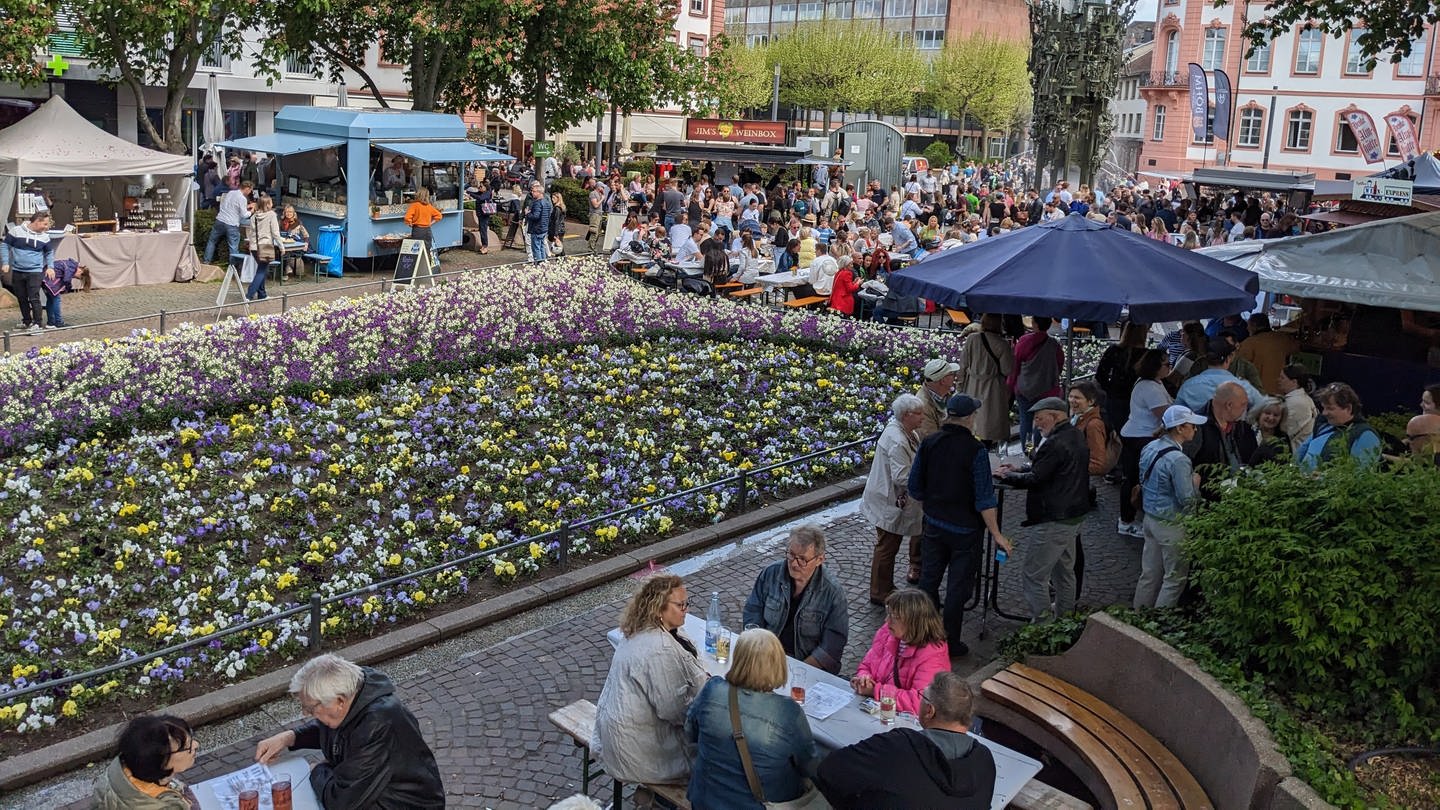 Besucher sitzen und stehen auf dem Mainzer Schillerplatz beim WeinHerbst an Ausschank- und Essensständen. (Foto: Jürgen Metschurat)