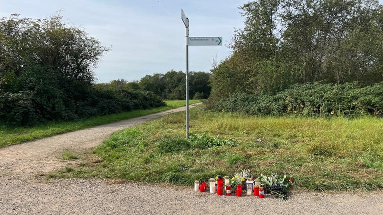 Auf dem Foto stehen mehrere Kerzen am Rand eines Feldweges: Bei der Messerstecherei in Bingen gab es einen Toten, für die Hinterbliebenen soll jetzt gespendet werden