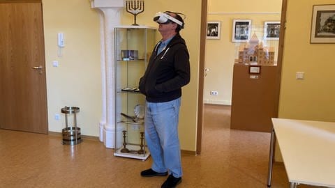 Ein Mann trägt eine VR-Brille und hebt den Kopf. (Foto: SWR)