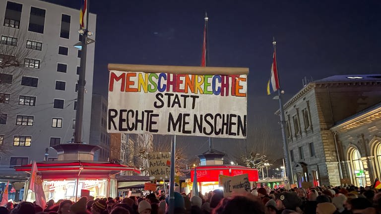 Demonstrierende halten in Mainz ein Schild mit der Aufschrift "Menschenrechte statt rechte Menschen" hoch. (Foto: SWR)