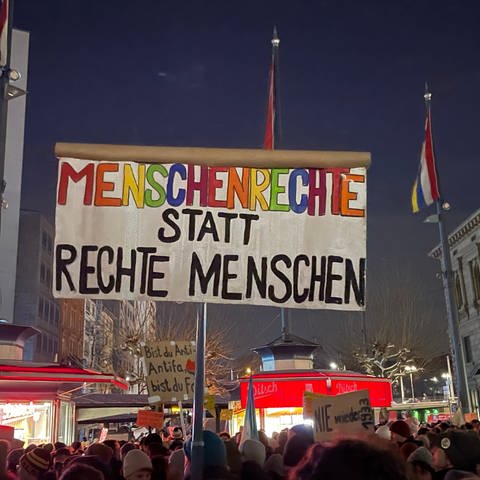 Demonstrierende halten in Mainz ein Schild mit der Aufschrift "Menschenrechte statt rechte Menschen" hoch. (Foto: SWR)