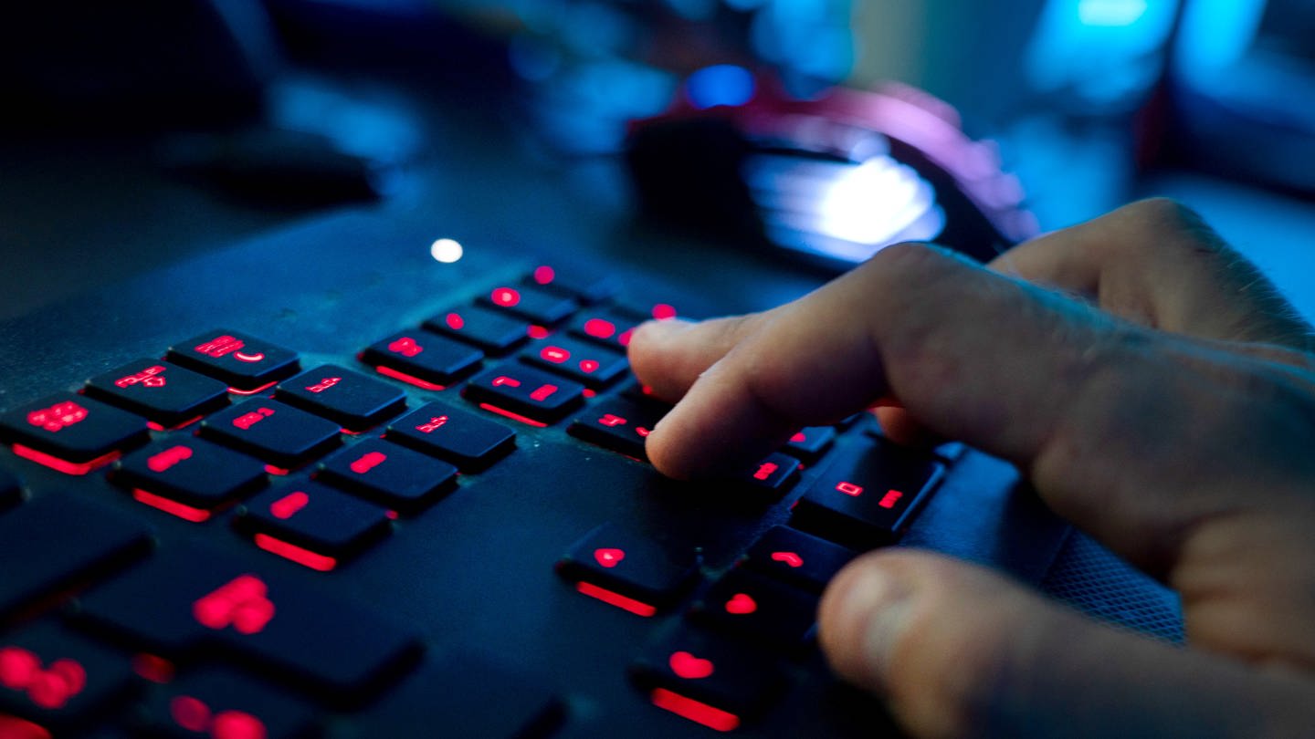 Ein Mann sitzt am Rechner und tippt auf einer Tastatur. In Mainz wurde ein Mann von seiner Internetbekannschaft erpresst. Der Mann hat Anzeige bei der Polizei erstattet. (Foto: dpa Bildfunk, Nicolas Armer)