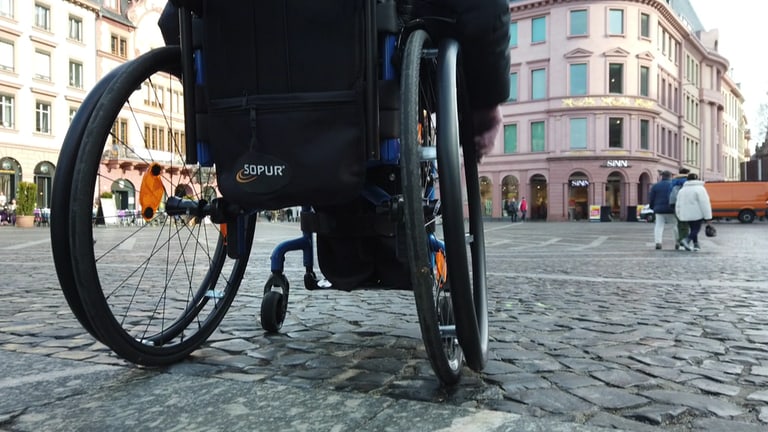 Eine Frau fährt mit dem Rollstuhl durch Mainz. (Foto: SWR)