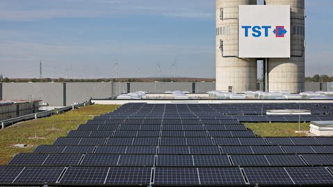 Auf einem Dach einer TST-Lagerhalle stehen einige Photovoltaik-Anlagen. (Foto: EWR/TST)