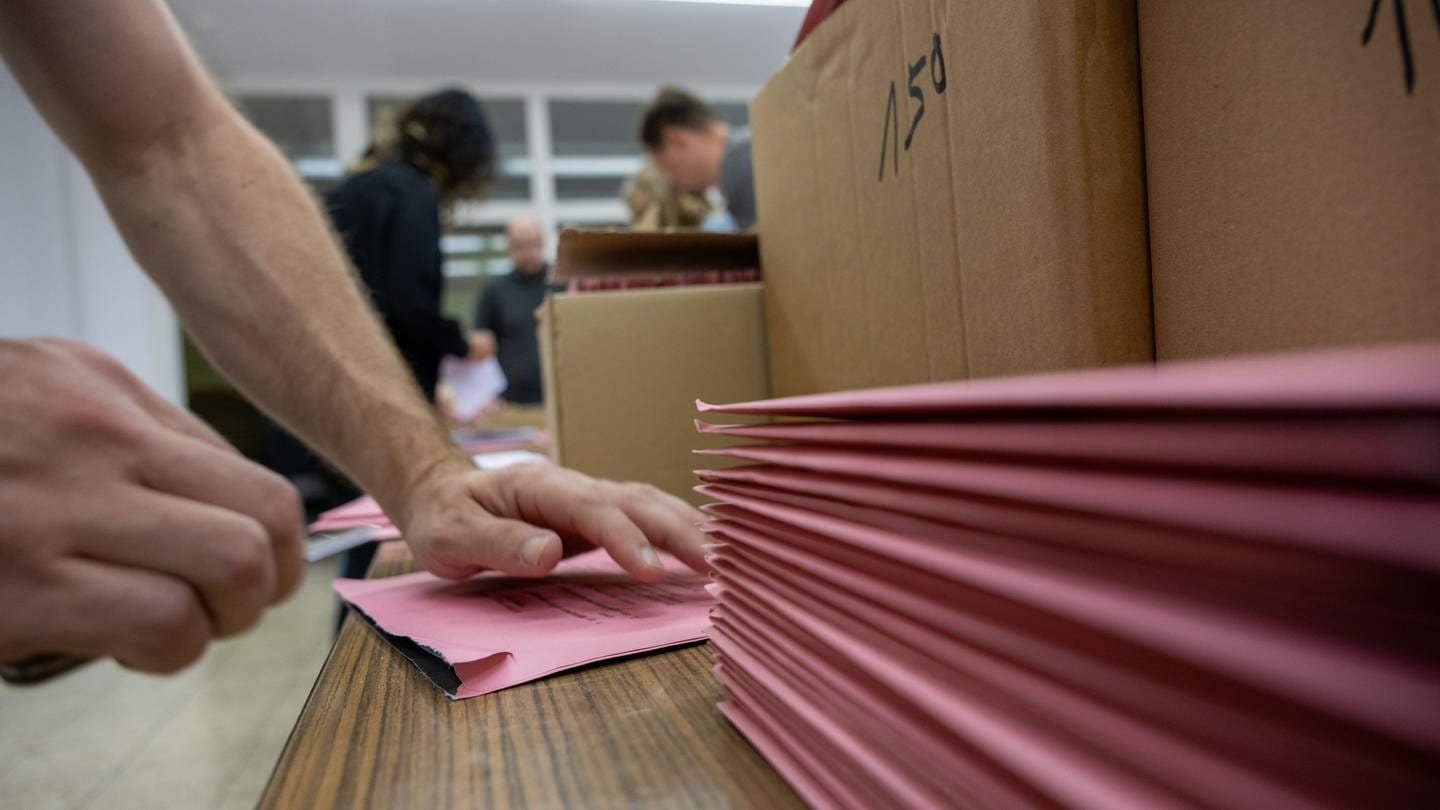 Wahlhelfer öffnen in einem Wahllokal Briewahlunterlagen. (Foto: dpa Bildfunk,  Pia Bayer)