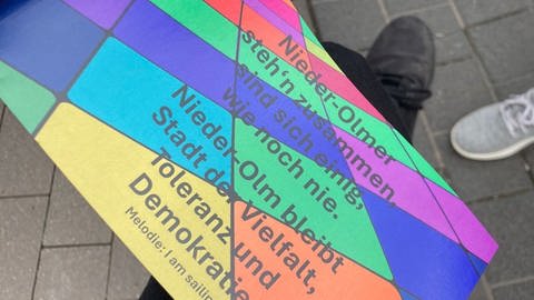 Die Nieder-Olmer stehen zusammen. Die Stadt sieht sich als Stadt der Vielfalst, Toleranz und Demokratie. Das steht auf einem Plakat zur Demo am Sonntag. 