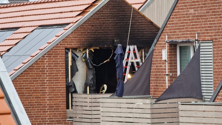 Auf dem Bild ist das verkohlte Fenster der Wohnung zu sehen: Brand in Mehrfamilienhaus in Ingelheim