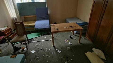 In der ehemaligen Paracelsus-Klinik in Bad Münster am Stein ist ein Zimmer verwüstet, Matratzen und Möbel stehen im Raum, auf dem Boden liegt Müll. (Foto: Dinko Ivanov)
