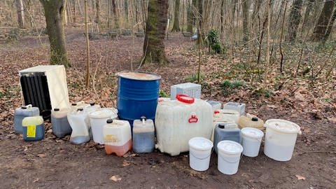 Unbekannte haben illegal Müll im Lennebergwald bei Mainz abgestellt, darunter Eimer und Kanister mit Flüssigkeiten, Autobatterien und einen Kühlschrank