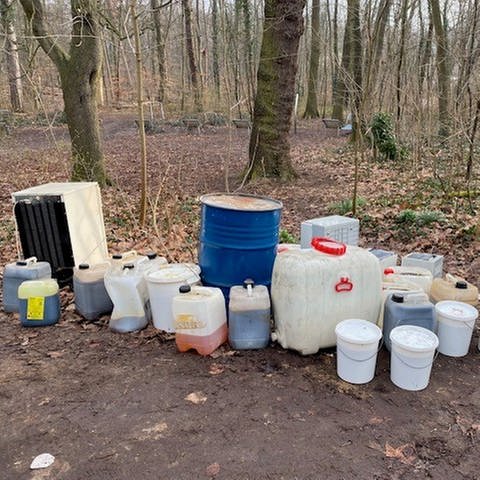Unbekannte haben illegal Müll im Lennebergwald bei Mainz abgestellt, darunter Eimer und Kanister mit Flüssigkeiten, Autobatterien und einen Kühlschrank