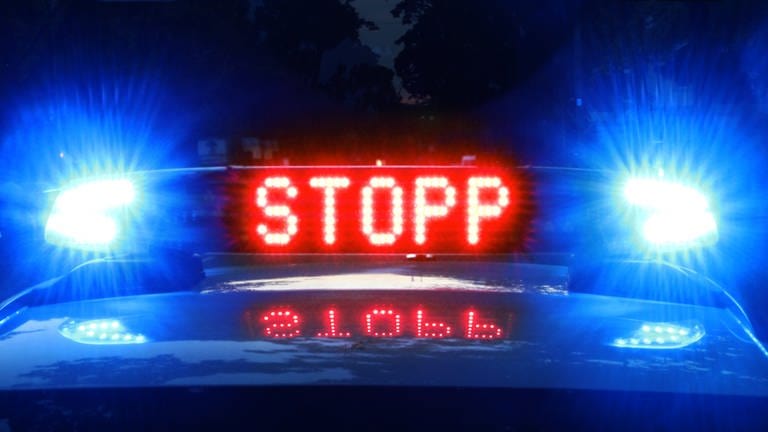 Auf einem Polizeiauto leuchtet in Rot das Wort "Stopp".  (Foto: SWR, D. Brusch (Symbolbild))