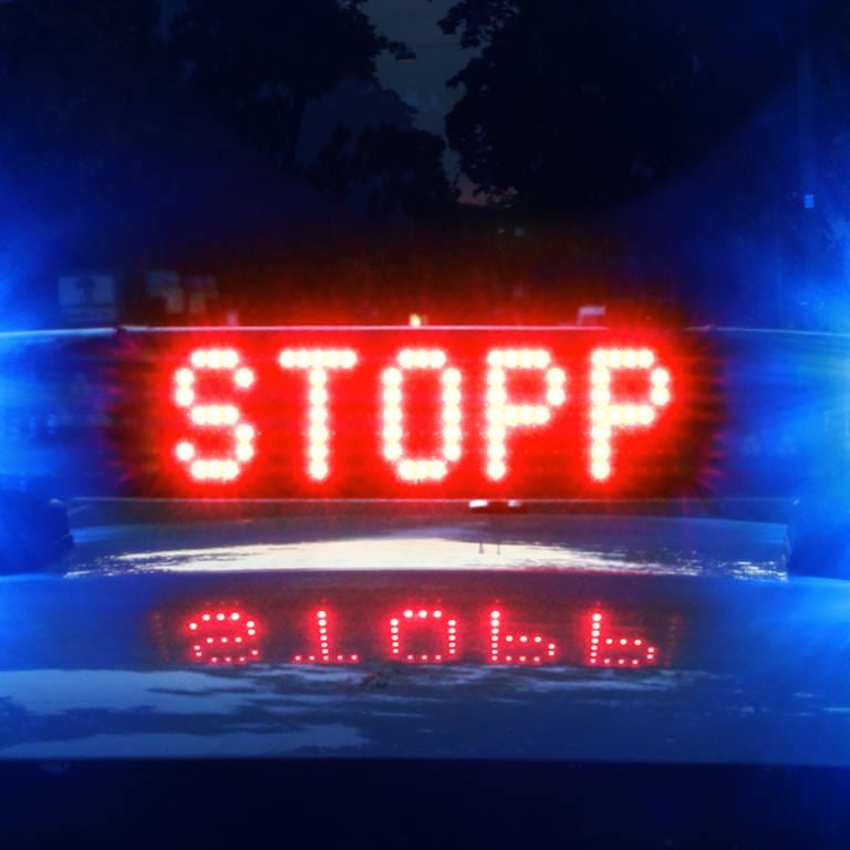 Auf einem Polizeiauto leuchtet in Rot das Wort "Stopp".  (Foto: SWR, D. Brusch (Symbolbild))