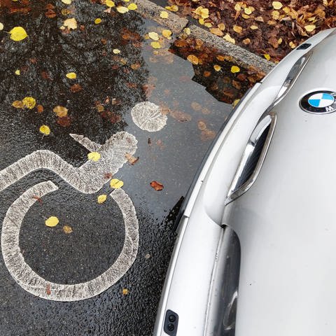 Ein BMW steht auf einem Behindertenparklpatz und fährt fast Polizisten um. (Symbolbild) (Foto: picture-alliance / Reportdienste, Wolfram Steinberg)