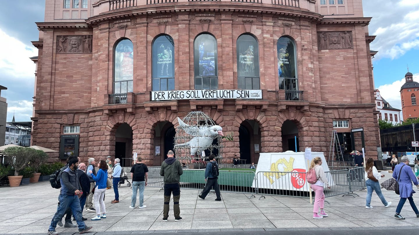 Mainzerinnen und Mainzer schauen sich die Friedenstaube vor dem Mainzer Staatstheater an. (Foto: SWR)