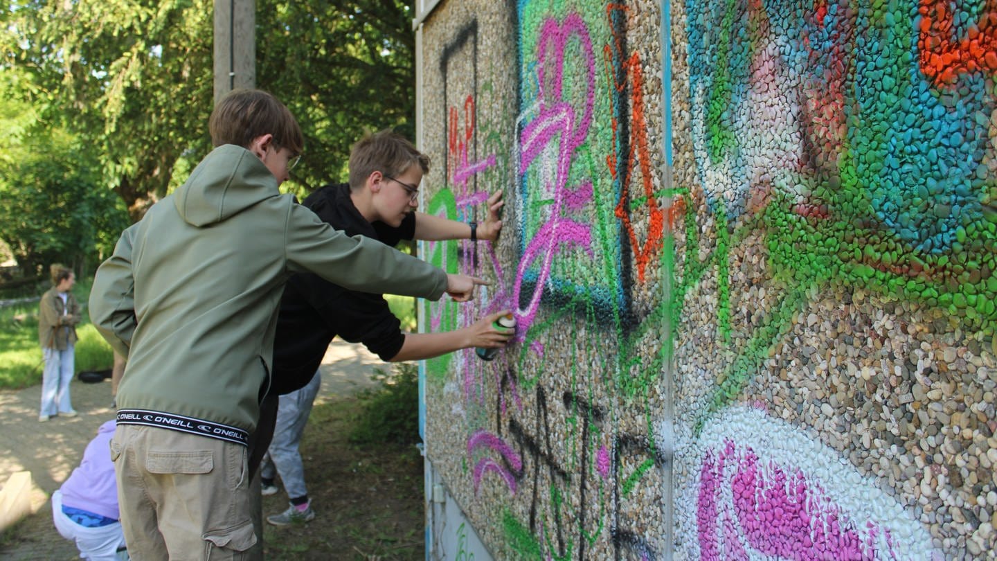 Zwei Jugendliche besprühen das alte Hallenbad in Oppenheim mit Graffiti. (Foto: SWR, Ben Bukes)