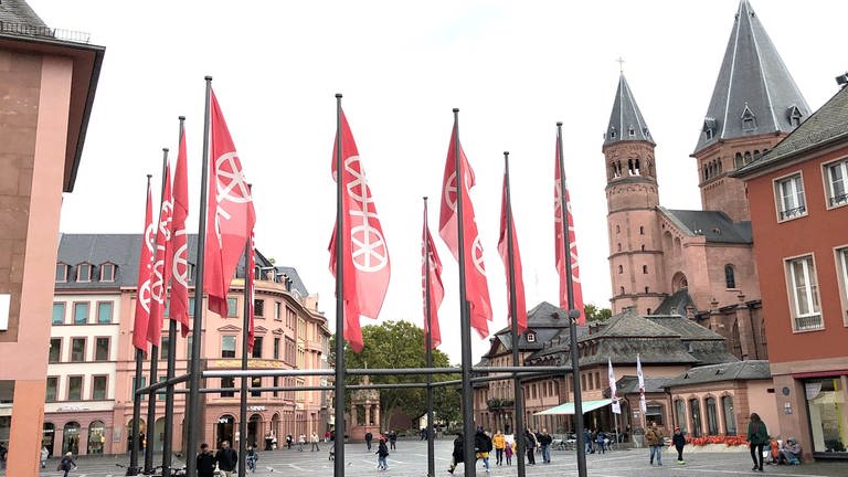 Fahnen mit dem Mainzer Rad wehen in Mainz auf dem Marktplatz vor dem Dom.