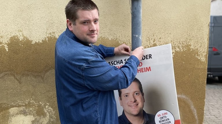 Der junge Bretzenheimer Sascha Schneider hängt sein eigenes Wahlplakat in Bretzenheim auf. (Foto: SWR, Sibylle Jakobi)