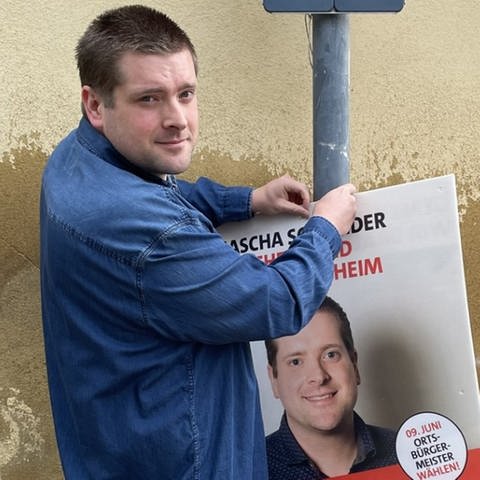 Der junge Bretzenheimer Sascha Schneider hängt sein eigenes Wahlplakat in Bretzenheim auf.