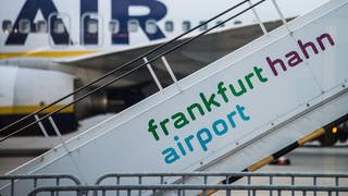 Eine Flugzeugtreppe mit der Aufschrift Frankfurt Hahn Airport - im Hintergrund steht eine RyanAir Maschine (Foto: picture-alliance / Reportdienste, dpa Bildfunk, Andreas Arnold)