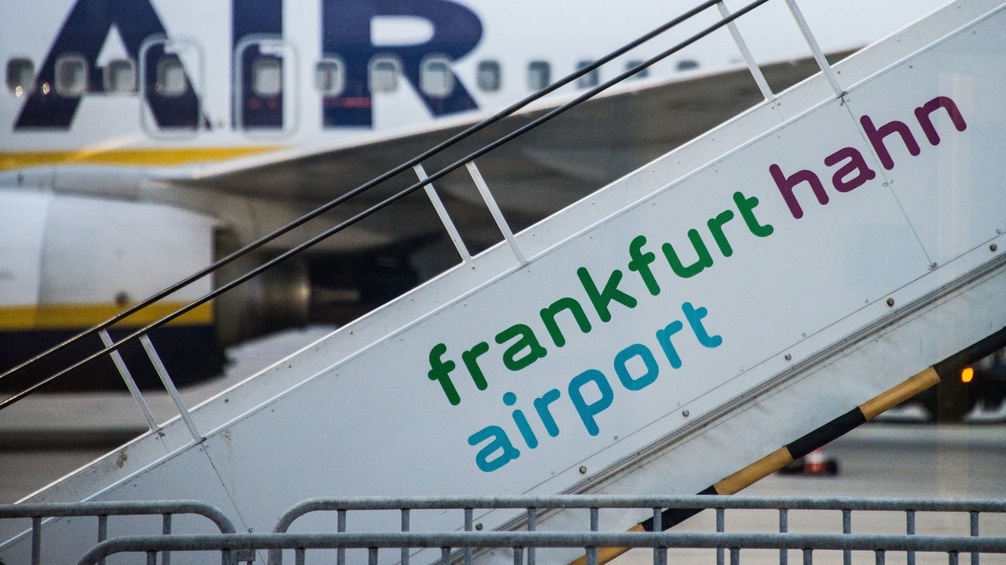 Eine Flugzeugtreppe mit der Aufschrift Frankfurt Hahn Airport - im Hintergrund steht eine RyanAir Maschine