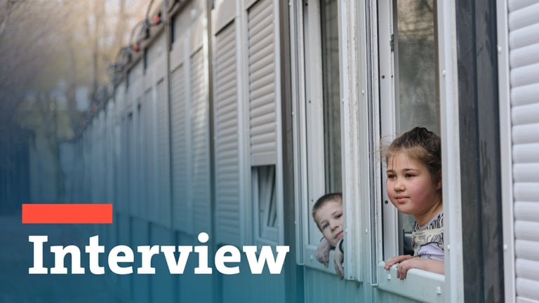 Zwei Kinder schauen aus den Fenstern einer Unterkunft für Asylsuchende. (Foto: dpa Bildfunk, picture alliance/dpa/SOPA Images via ZUMA Press Wire | Mykola Tys)