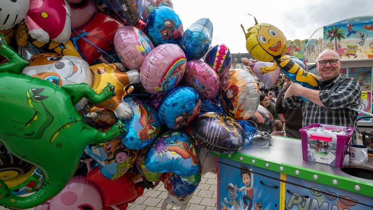 Mitveranstalter Thorsten Dierichs füllt einen Motivballon bei der Kirmes "Allerheiligenmesse" auf dem Viehmarktplatz in Trier (Foto: dpa Bildfunk, picture alliance/dpa | Harald Tittel)