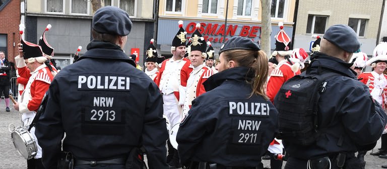 Karnevalisten feiern beim Karneval in Köln und werden dabei von Polizisten beobachtet . (Foto: dpa Bildfunk, Picture Alliance)