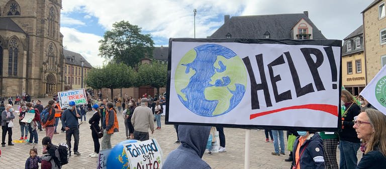 Schild mit "Help" auf der Kundgebung der Klimaaktivisten in Trier. (Foto: SWR, Andrea Meisberger)