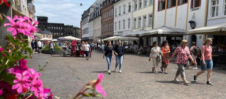 Passanten laufen entlang der Fußgängerzone in Trier, im Hintergrund die Porta-Nigra: Einzelhändler rechnen wegen des Feiertags in Luxemburg am 23.06. mit mehr Kunden (Foto: SWR, Martin Schmitt)