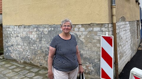 Hannelore Fuchs vor einem durch die Flutkatastrophe 2021 beschädigten Haus. (Foto: SWR, Jana Hausmann)