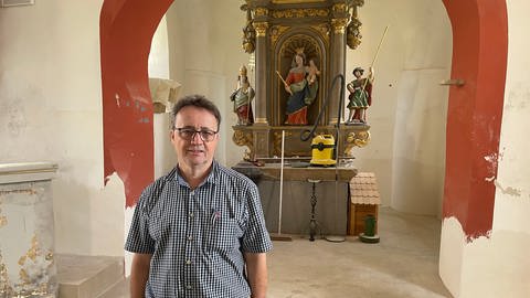 Der Bürgermeister Franz-Josef Ferring in der St.Silvester Kirche in Minden. Er hofft, dass die Hochwasserschäden dort bald beseitigt sind. (Foto: SWR, Jana Hausmann)