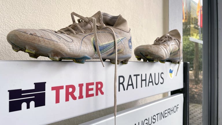 Fußballschuhe auf dem Eingangsschild am Rathaus Trier (Foto: SWR)